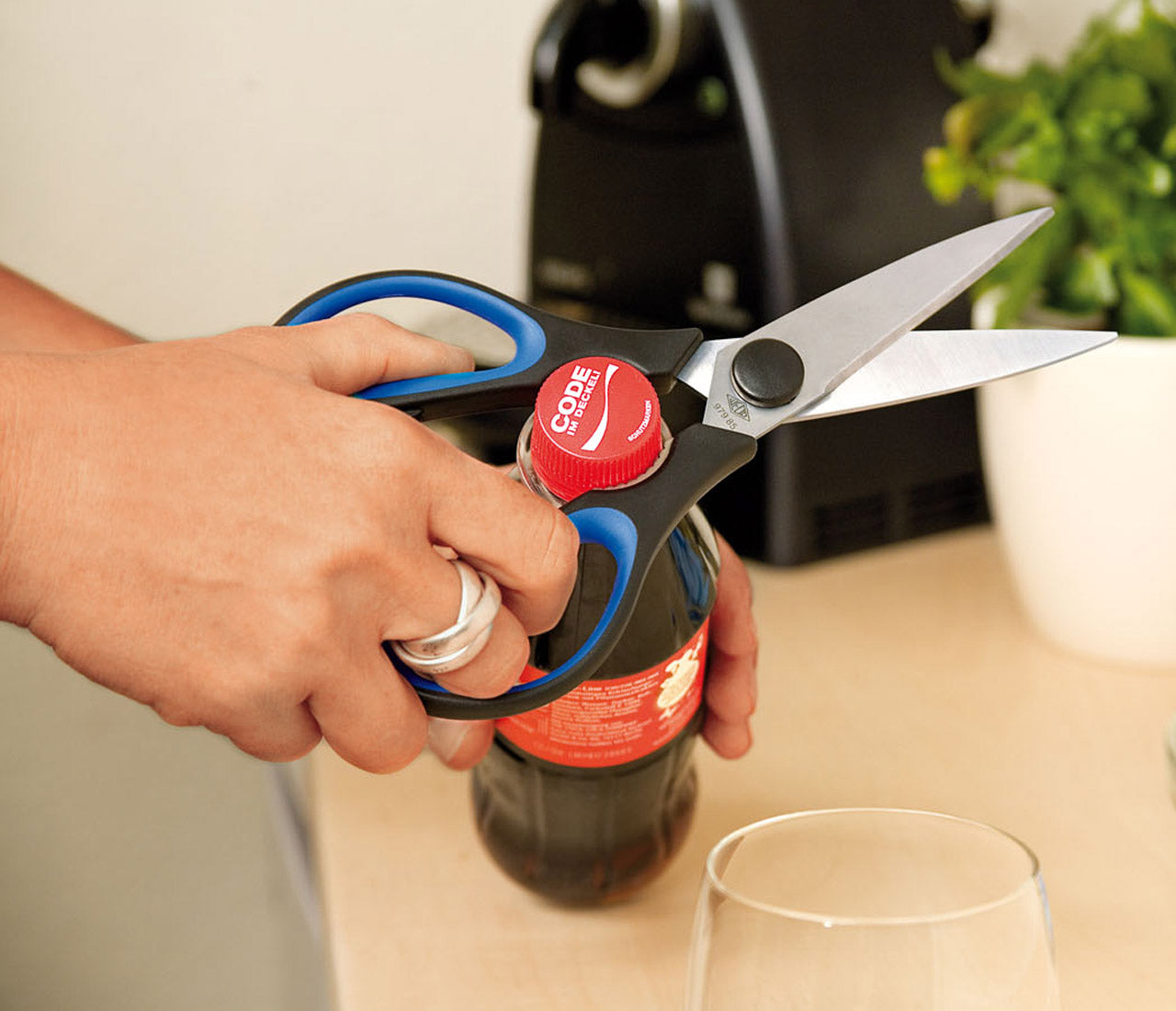 Soft-Cut-Premium Haushaltsschere von WEDO bei der Anwendung in der Küchen öffnen einer Flasche mit der aufdrehhilfe der Schere